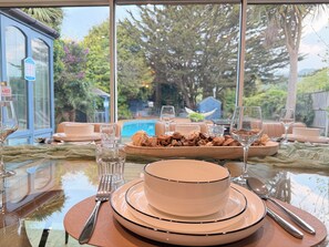 Una mesa de comedor dispuesta con platos, tazones, vasos y cubiertos.