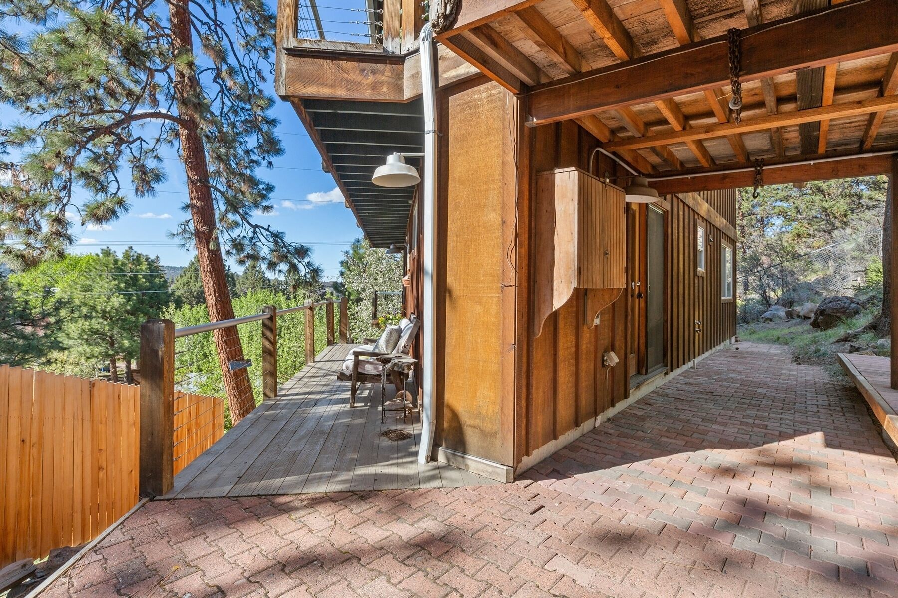 A wooden deck with a chair and a hanging light fixture.