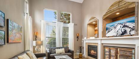 A living room with leather sofas, a fireplace, and artwork on the walls.