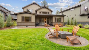 A two-story house with a patio area featuring outdoor furniture and a fire pit. - New Listing! Gorgeous Home | Hot Tub | Minutes to Mt. Bachelor (Bend)