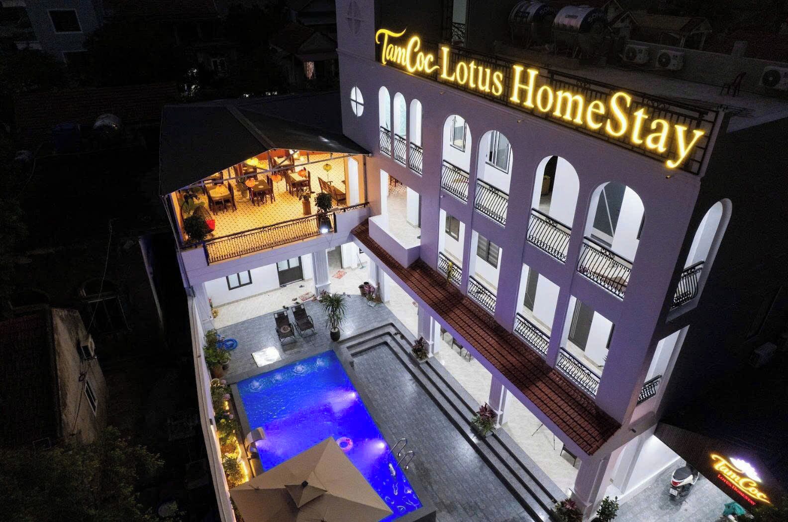 A multi-story building with a pool area, balconies, and a sign reading 'TanCoc Lotus HomeStay.'