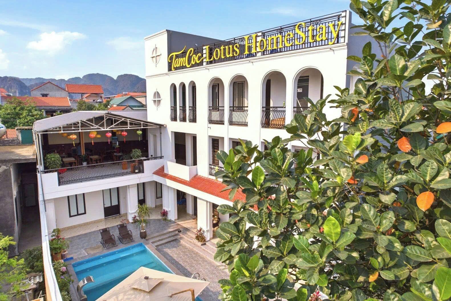 Un bâtiment sur lequel on peut lire l’inscription « TanCoc Lotus Home Stay », avec une zone comprenant une piscine.