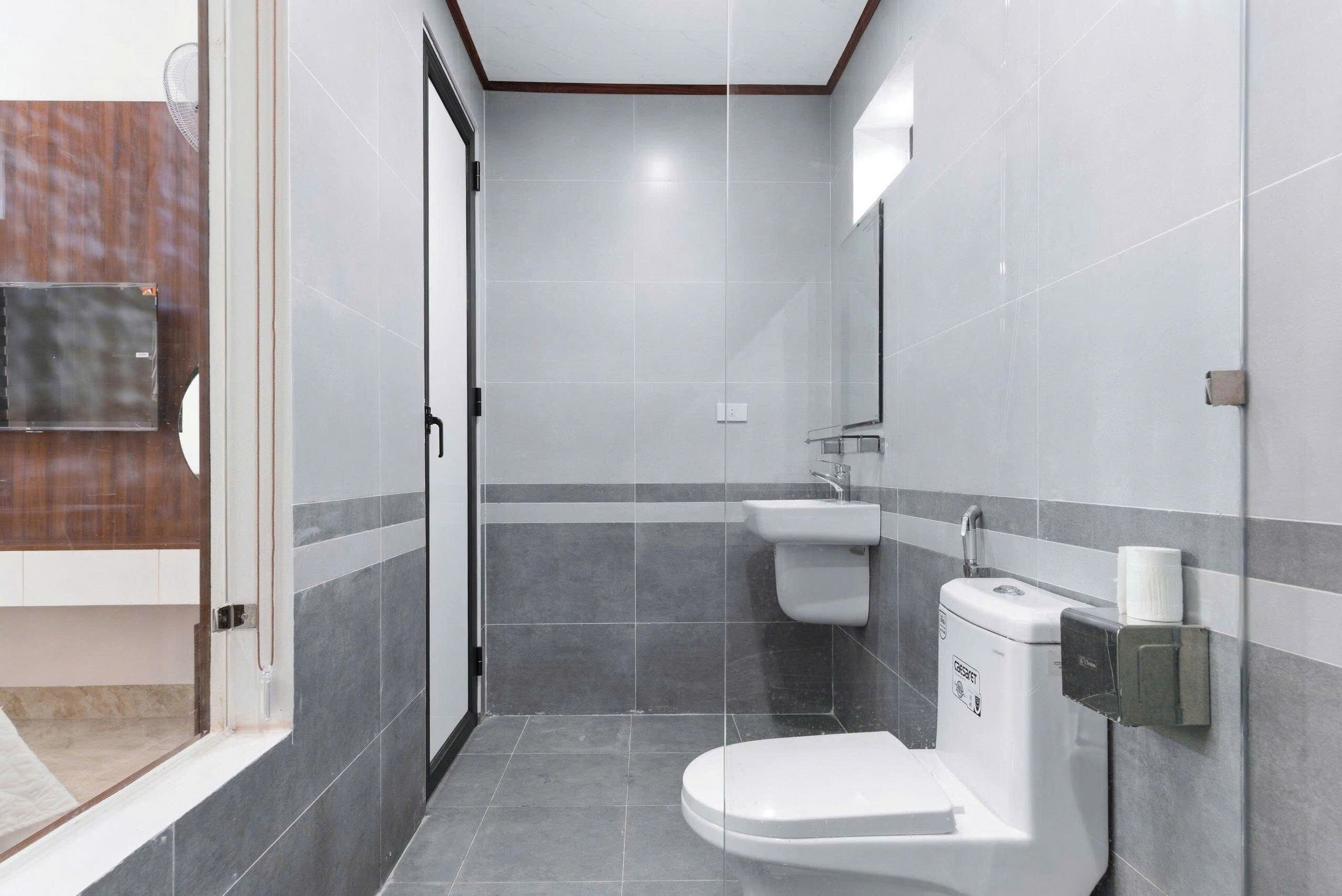 Een moderne badkamer met toilet, wastafel en douchehoek.