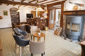A cozy interior with a fireplace, seating area, and a wine rack.