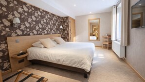 A bedroom with a large bed, bedside tables, a mirror, and a desk. - Hôtel La Ferme de Sy (Ferrières)