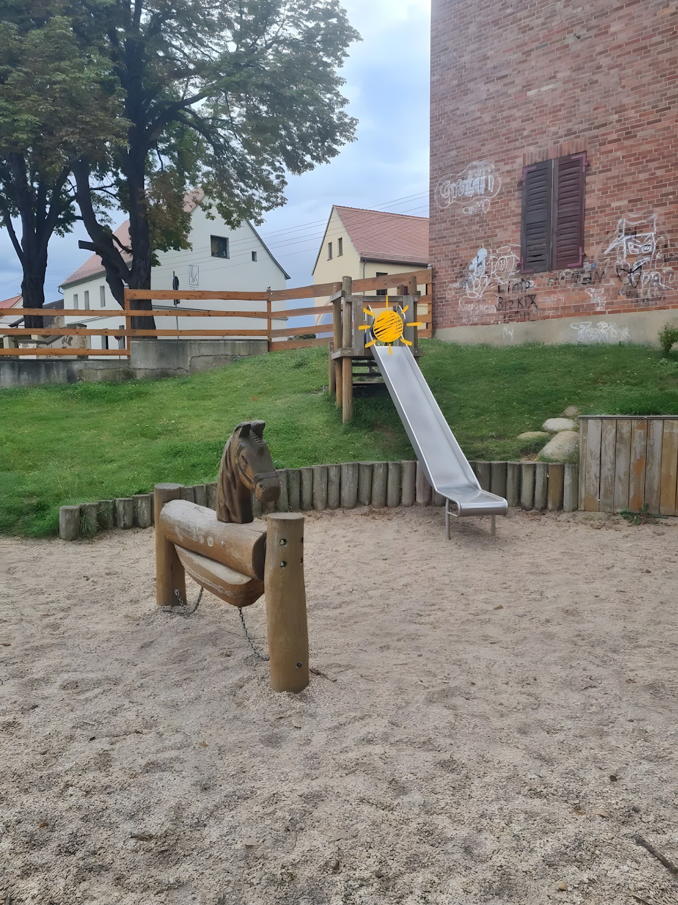 Ein Spielplatz mit einer Rutsche und einer Holzbank.