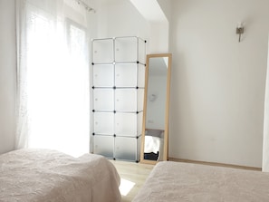 A bedroom with a bed, a wardrobe, a mirror, and a light fixture. - Bright Seaside Apartment in Cala Millor | Beach Nearby (Son Servera)