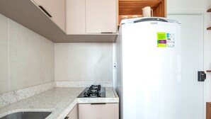 A kitchen with a white refrigerator, a stainless steel sink, and a granite countertop. - Botanik With Coworking, Pet Place, and Skyview By Carpediem (Recife)