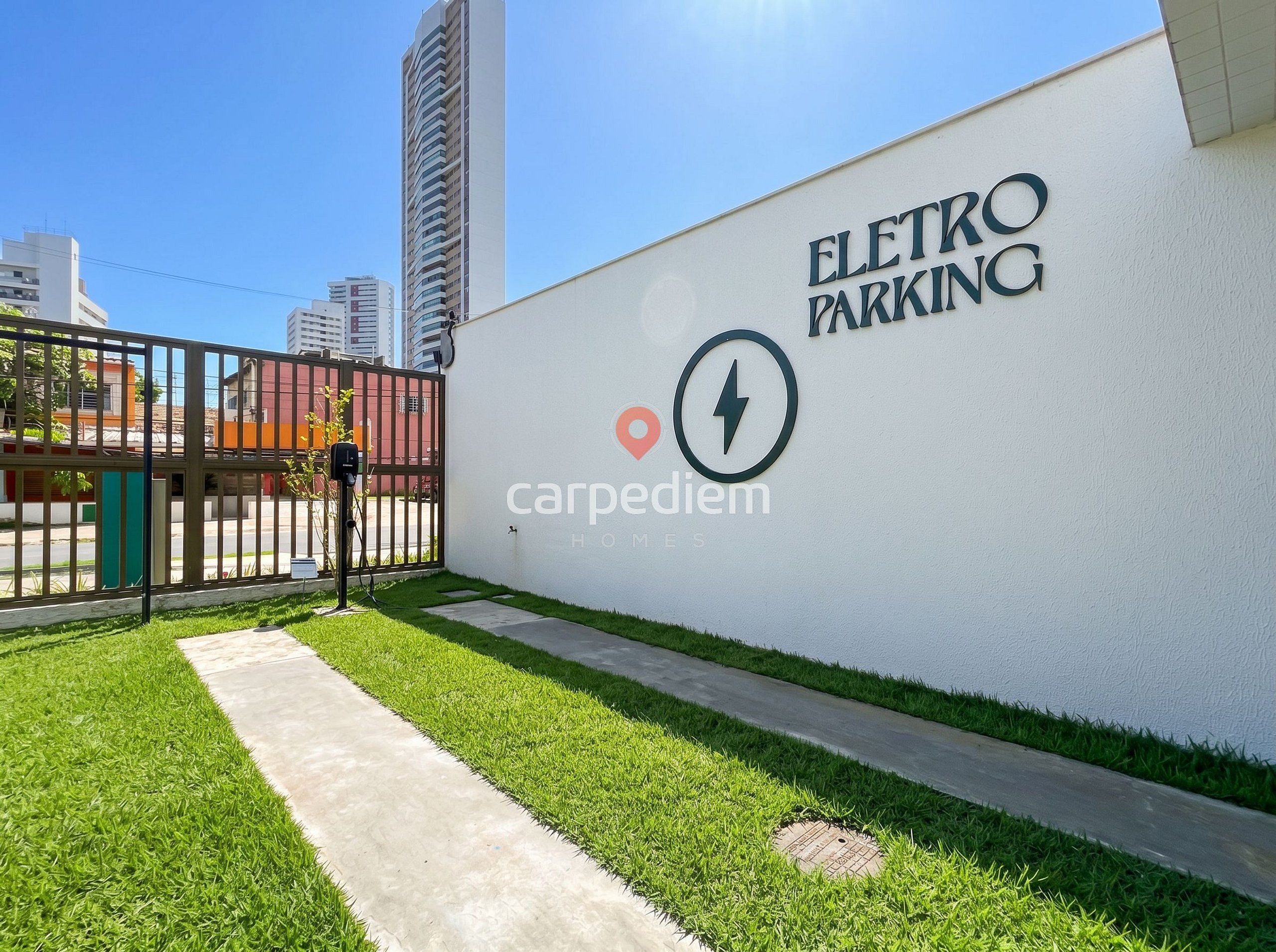 An outdoor electric vehicle charging station with a wall sign reading 'ELETRON PARKING' and 'carpediem HOMES'.