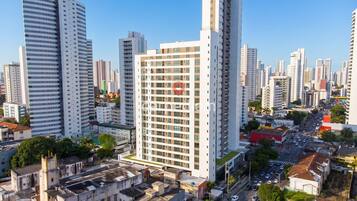 Um edifício alto com um logotipo vermelho bem visível, rodeado por outros edifícios imponentes em um horizonte urbano.
