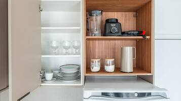 Een keuken met een ingebouwd apparaat, een koffiezetapparaat en opbergplanken.