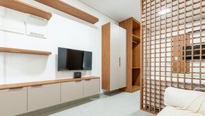 Une chambre moderne avec un lit, une télévision et une cloison en bois.