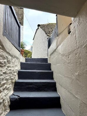 A narrow staircase with white walls and dark steps leading to a tiled roof. - Poppy's Studio Collection - Harbour Townhouse and The Hideaway (Mevagissey)