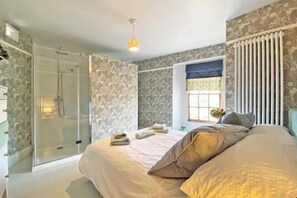 A bedroom with a bed, a shower, a window, and a radiator. - Poppy's Studio Collection - Harbour Townhouse and The Hideaway (Mevagissey)