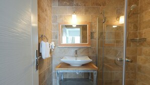Un baño con lavamanos, espejo y ducha.