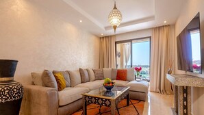 Ein modernes Wohnzimmer mit Sofa, Couchtisch, dekorativer Vase und Fernseher.