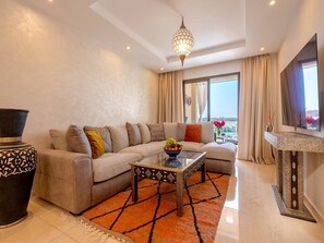 Ein modernes Wohnzimmer mit Sofa, Couchtisch, dekorativer Vase und Fernseher.