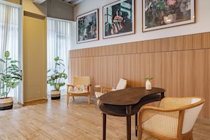 A room with a wooden floor, a round table, wicker chairs, and two potted plants. - Luxury 3BR in Roma Norte – Walk to Top Spots (Ciudad de México)