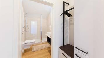 Ein modernes Badezimmer mit Dusche, Toilette und Holzboden.