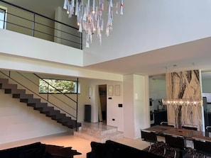 A modern interior with a staircase, a dining area, and a kitchen.