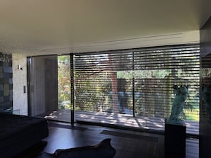 A modern interior with a large sliding glass door, a sofa, and a sculpture.