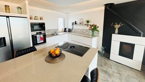 Eine moderne Küche mit Einbauofen, Mikrowelle und Essbereich mit Tisch und Stühlen.