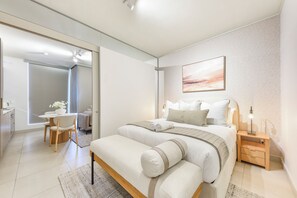 Ein modernes Schlafzimmer mit Bett, Nachttischen, Schreibtisch und Stuhl.