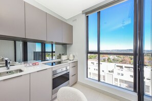 Eine moderne Küche mit großem Fenster, Backofen und Arbeitsplatte mit Geräten.