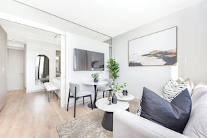 Ein modernes Wohnzimmer mit einer Couch, einem Couchtisch und einem Essbereich mit Stühlen und einem Tisch.