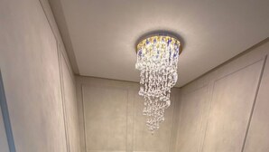Una escalera con barandilla de metal y un candelabro colgando.