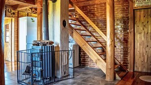 Ein rustikales Interieur mit einer Holztreppe, einer Backsteinwand und einem Schild, das ein Restaurant anzeigt.