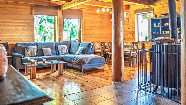 Ein Holzinterieur mit einer Couch, einem Esstisch und Stühlen.