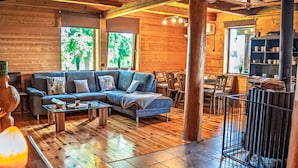 Ein gemütliches Blockhaus-Interieur mit einer Couch, einem Couchtisch und einem Essbereich.