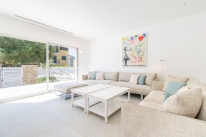 Una sala de estar moderna con un sofá, una mesa de centro y un ventanal grande.