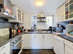A modern kitchen with white cabinets, a stainless steel stove, and a dishwasher.