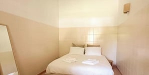 Ein Hotelzimmer mit einem Bett, einem Nachttisch und einer Wandleuchte.