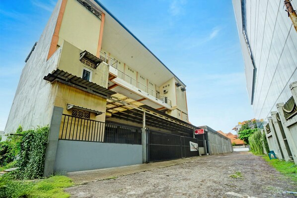 A building with a covered walkway, a gated entrance, and a sign indicating a 'No Parking' zone. - Inviting Standard DBL Stay W/wifi Parking Access (Surabaya)