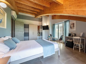 Een slaapkamer met een bed, een bureau, stoelen en een televisie.