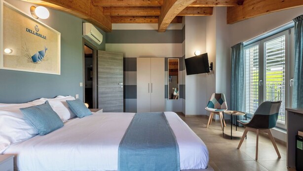 Una camera da letto con un letto, una TV, una scrivania e una sedia.