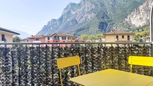 Un balcon avec vue sur une montagne et des bâtiments.
