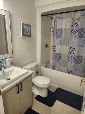 A bathroom with a white sink, toilet, and bathtub. - Cozy Riverview Apartment Modern Comfort and Scenic Views (Riverview)