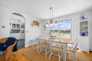 A dining area with a table, chairs, and a view of the outdoors. - East Sandwich Beach Escape with Marsh Views (East Sandwich)