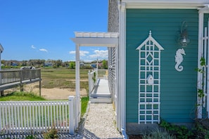 A coastal building with a white porch, a green door, and a decorative seahorse. - East Sandwich Beach Escape with Marsh Views (East Sandwich)