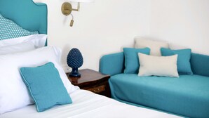 Una camera da letto ordinata con un letto, un comodino e un divano.