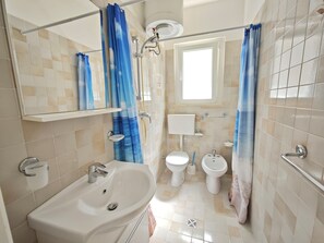 Ein Badezimmer mit Waschbecken, Toilette, Bidet und Dusche.