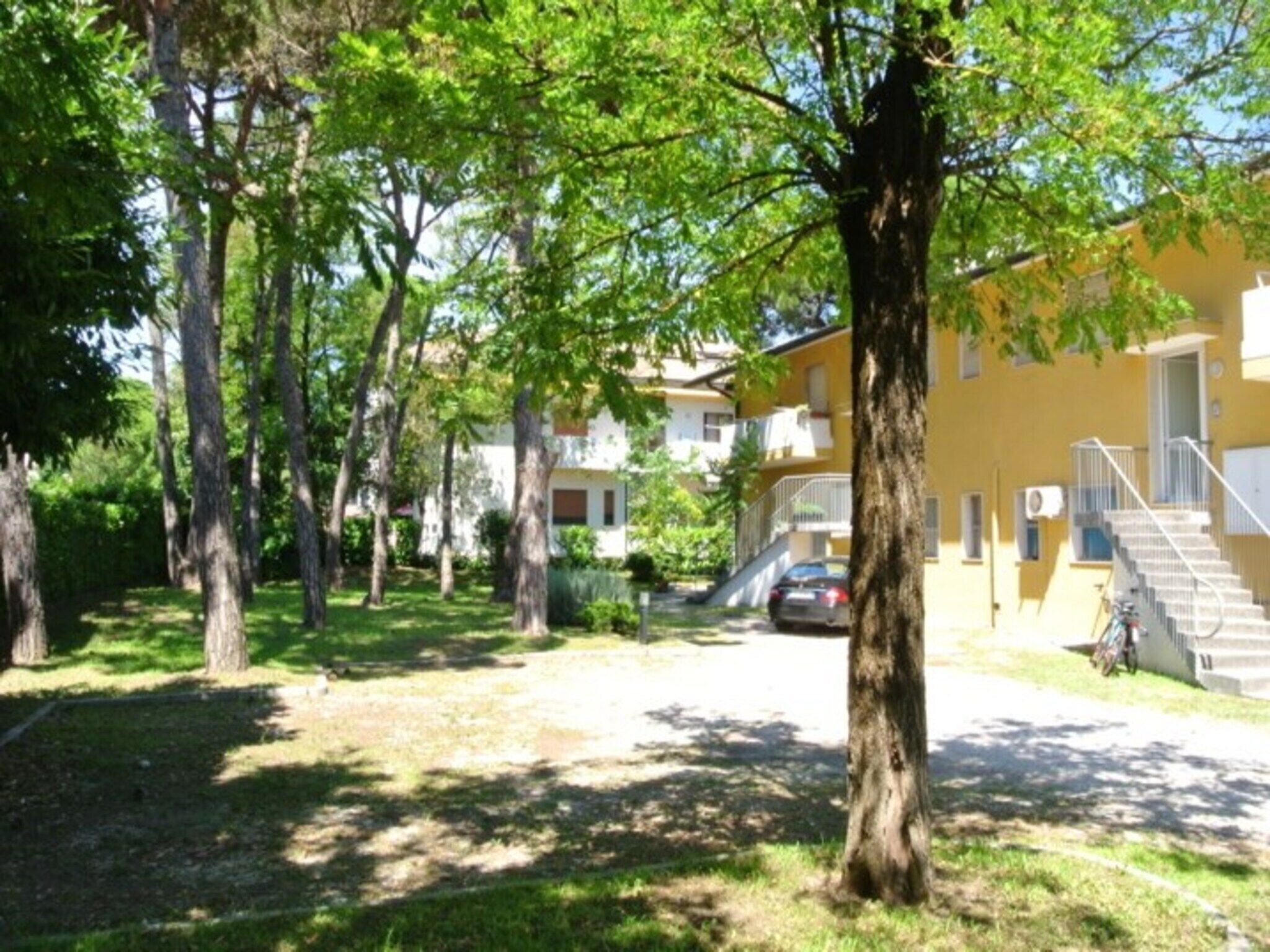 Ett bostadsområde med flera hyreshus, en gräsyta och träd.
