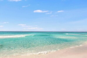 A beach with clear turquoise water and a sandy shore. - 🦩Book Me Baby! Emerald Coast Cabana in Panama City Beach🦩 (Panama City Beach)
