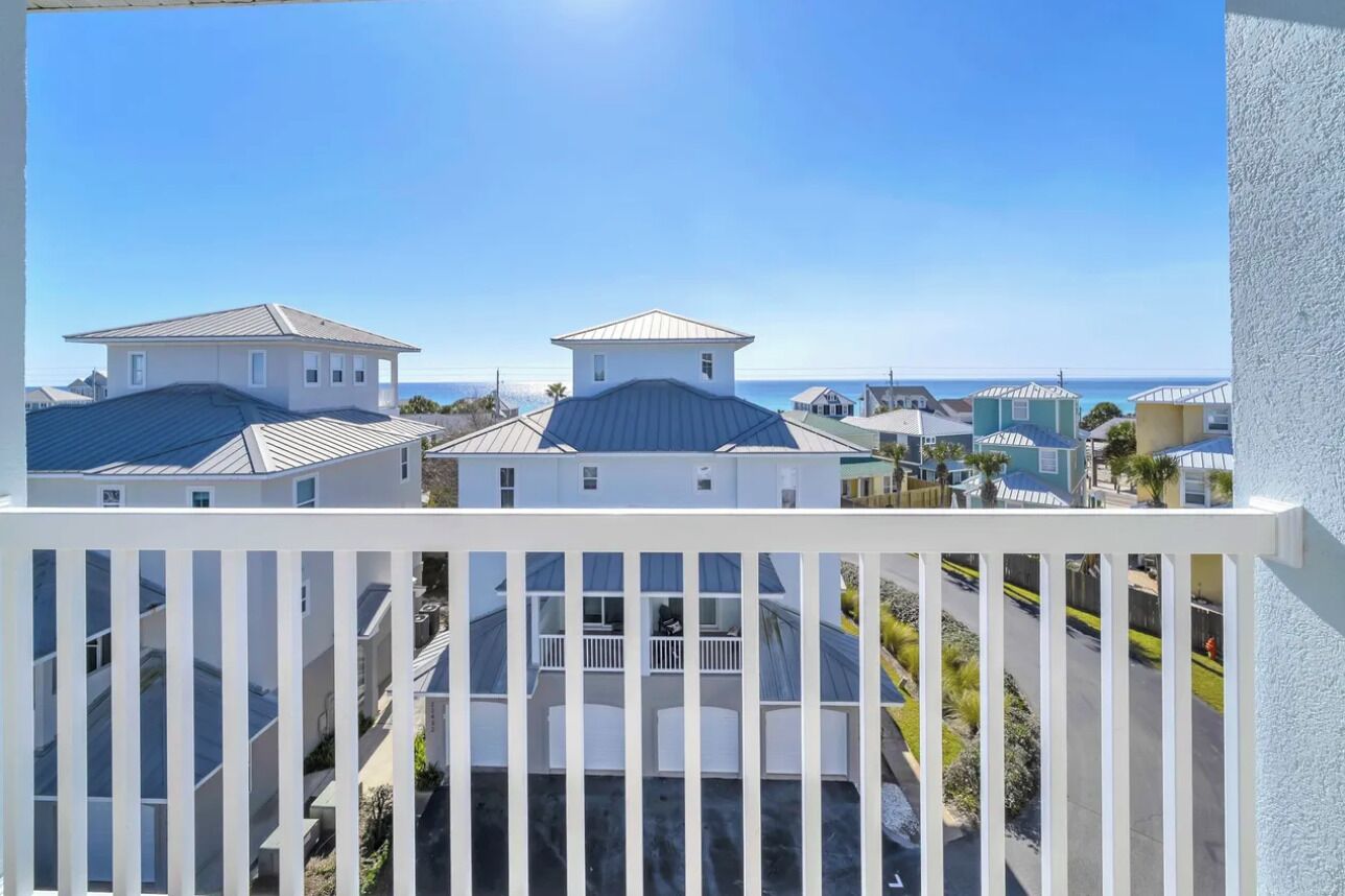 A residential area with houses, a balcony, and a clear sky.
