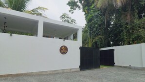 Una entrada cerrada por un portón a un edificio, con un cartel que dice 'HARU AHANGAMA'.