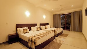 Habitación de hotel con dos camas, un ventilador de techo y vistas al exterior.